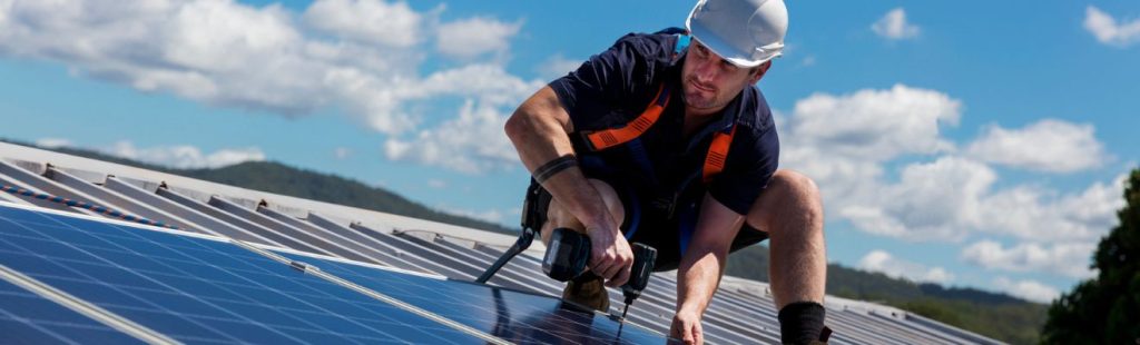 operario instalando paneles solares en el techo