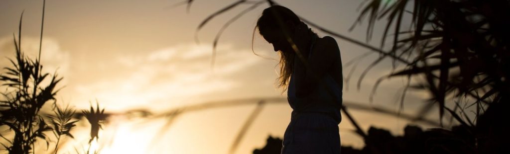 silueta de una mujer en el exterior anocheciendo