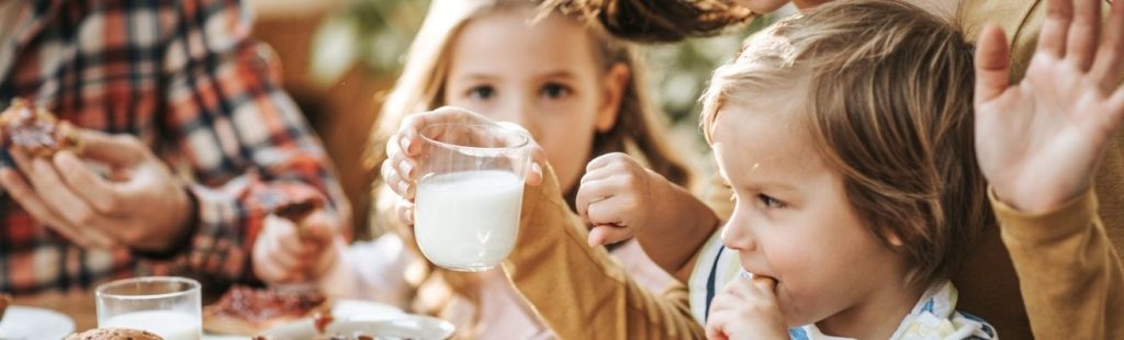 familia con niños pequeños bebiendo leche