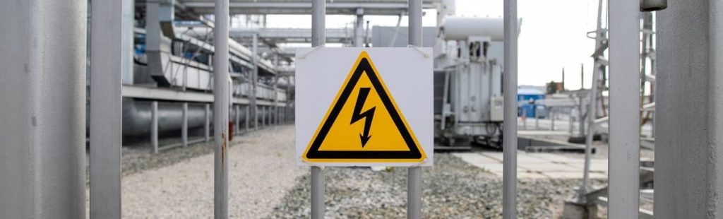 central electrica con cartel amarillo de riesgo electrico