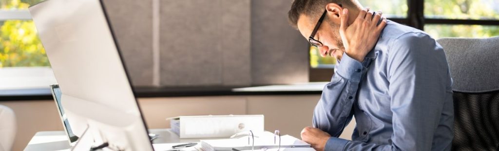 empleado sentado en su escritorio con dolor de cuello