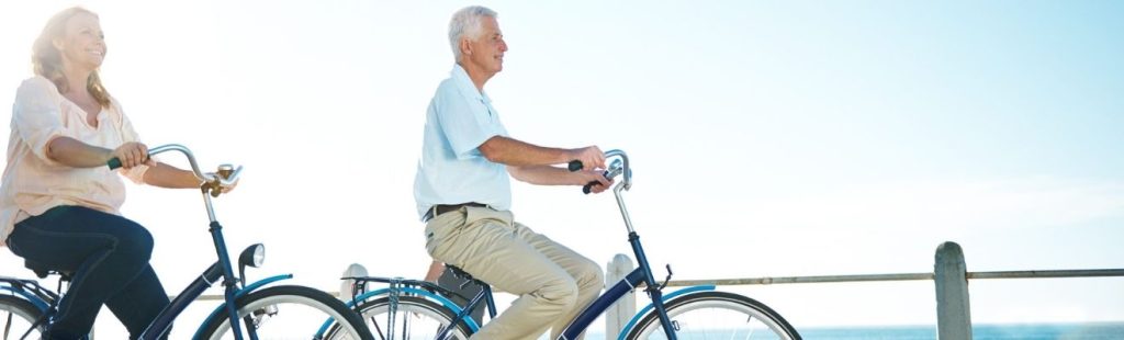 personas mayores en bicicleta por paseo marítimo